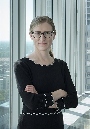 Foto von Marianne Jakl, die vor einem Fenster steht