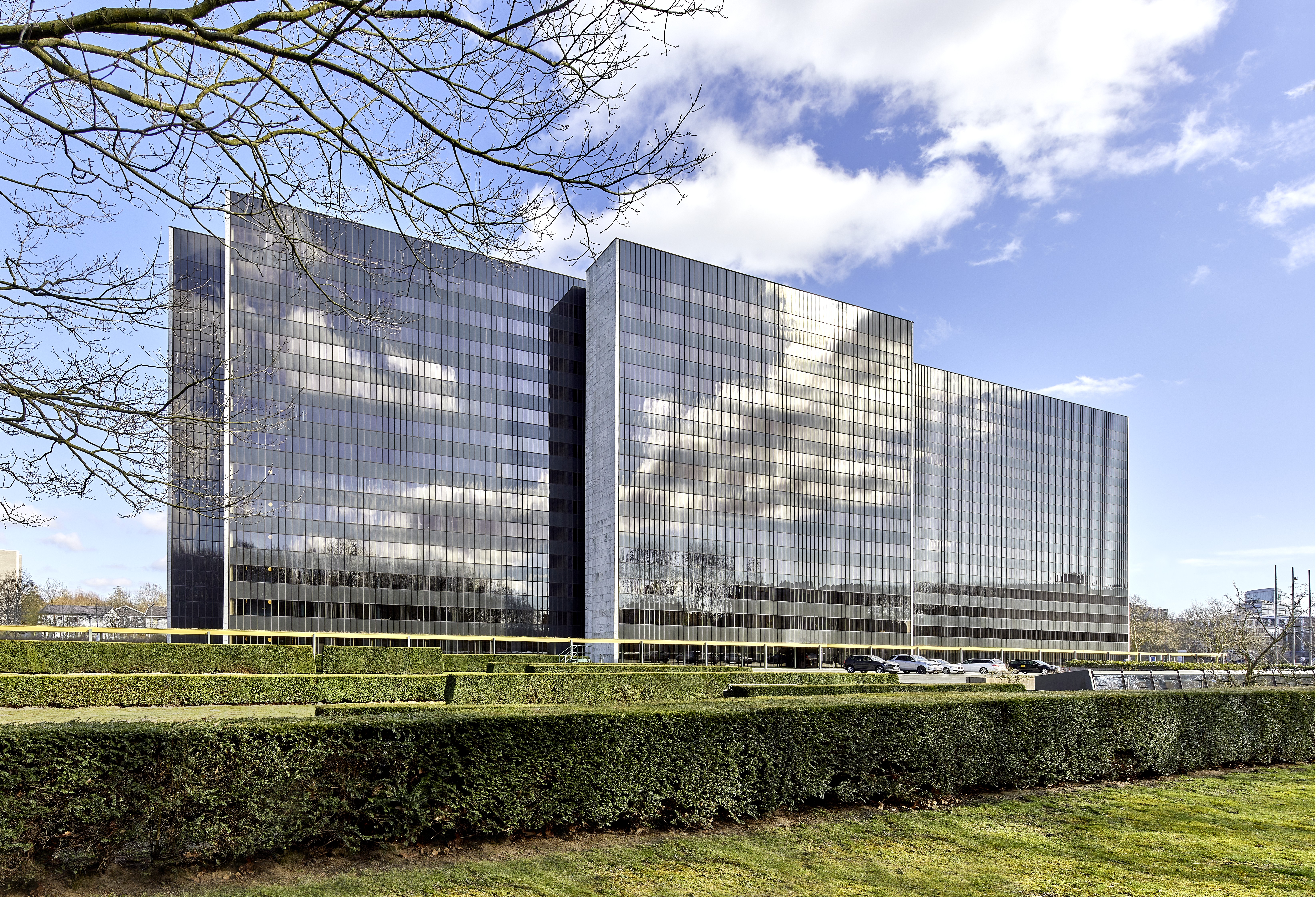 The picture shows an office building with a glass façade