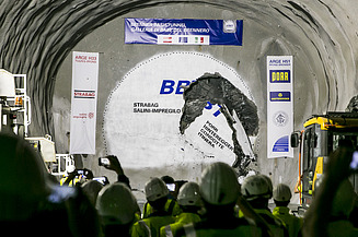 Foto einer Feier in einem Tunnel bei erlofgtem Durchbruch, an den Wänden hängen Transparente