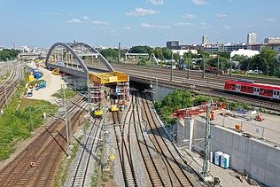 Foto vom Bau einer Brücke über Schienen aus der Vogelperspektive. 