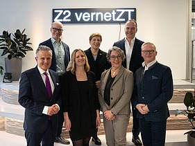 The picture shows five people standing in front of a light installation