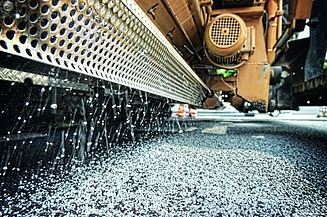 Foto zeigt einen Fertigerintegrierten Streuer im Einsatz