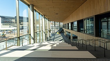 Bild von einem Innenraum, links eine Glasfront, durch die die Sonne scheint