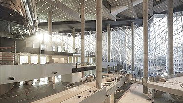  Foto von der Innenansicht Axel-Springer-Neubau. Es ist ein großer Raum mit vielen Fenstern.   