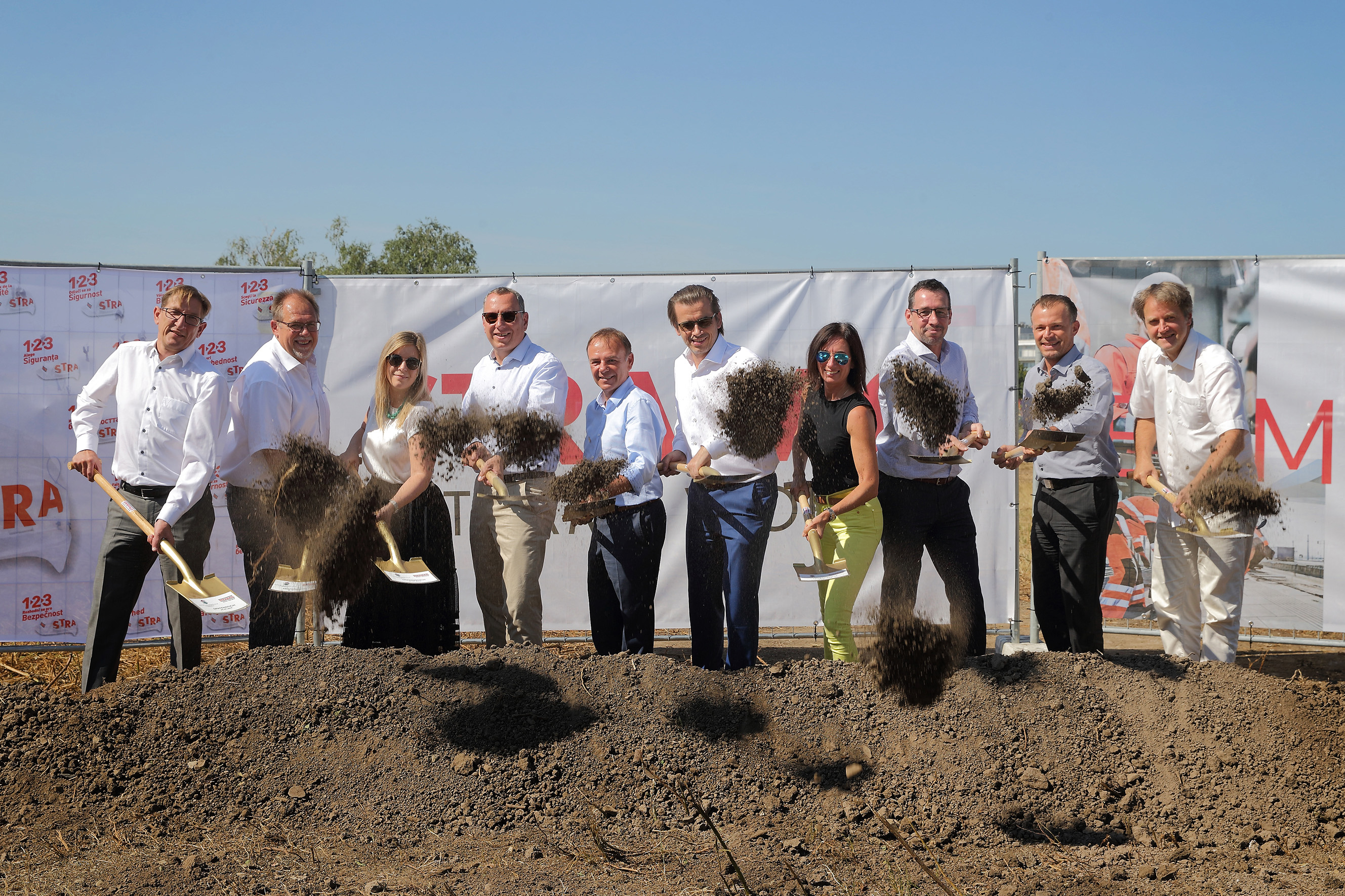 Foto von mehreren Personen mit Schaufeln in der Hand bei einem symbolischen Spatenstich