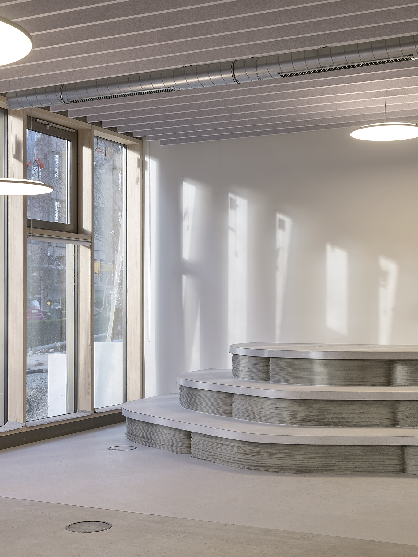 The picture shows three concrete steps in a modern foyer