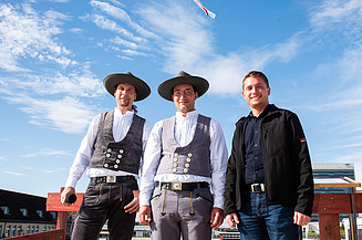 Foto von drei freundlich schauenden Männern beim hissen des Richtkranzkranz.