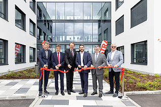Foto von sechst Personen, die ein rotes Band durchschneiden bei der Eröffnung des neuen STRABAG Standorts in St. Pölten