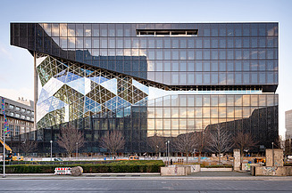 Foto von einem Bürogebäude von außen am Tag.  