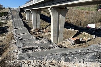 Foton von einer gesprengten Brücke, die Bruchteile liegen auf der Erde, daneben steht noch die zweite Brücke