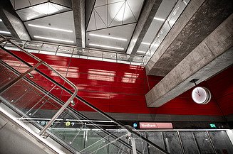 Foto von einer Rolltreppe mit einer bunten Wand.                