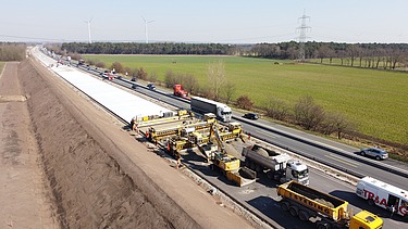 Das Bild zeigt den Betondeckeneinbau Ende März 2022 durch ein STRABAG-Projektteam auf einem Teilabschnitt der 30 km langen Strecke zwischen Lohne und Bramsche.