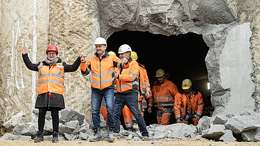 Nahaufnahme von mehren Personen in Schutzausrüstung beim feierlichen Durchschlag zur Wendlinger Kurve.