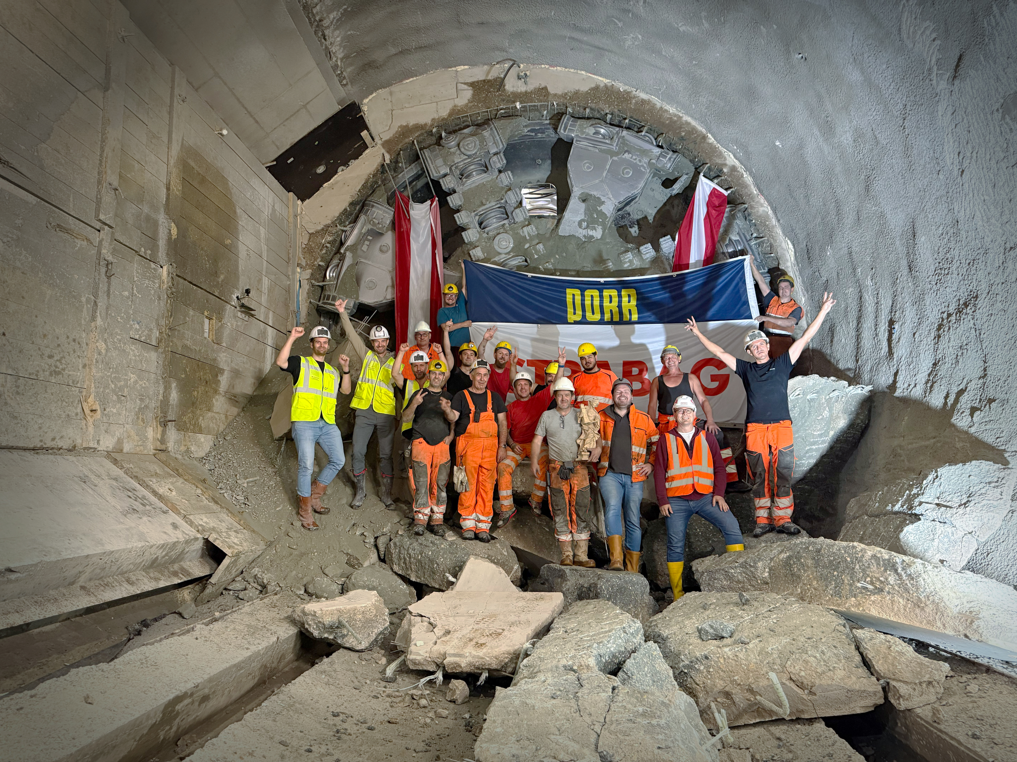 Mitarbeitende der ARGE U2 17-21 vor der Tunnelvortriebsmaschine Debohra nach dem erfolgreichen Tunneldurchschlag am Augustinplatz