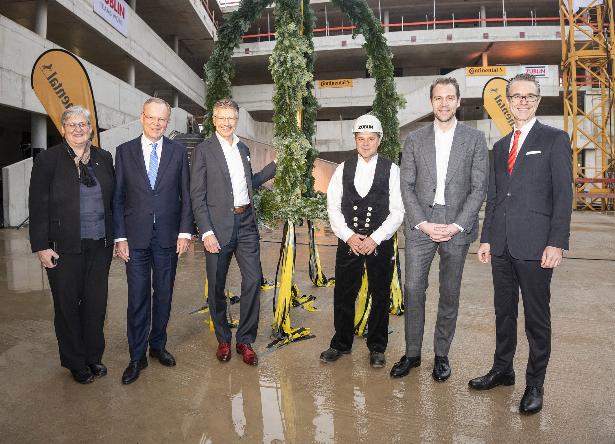 Foto von freundlich schauenden Personen vor dem Richtkranz.