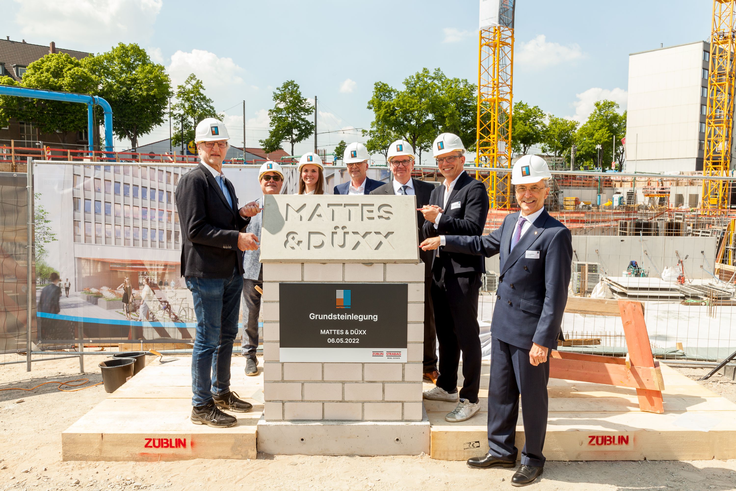 Foto von mehreren Personen, die freundlich schauen bei der Grundsteinlegung. 