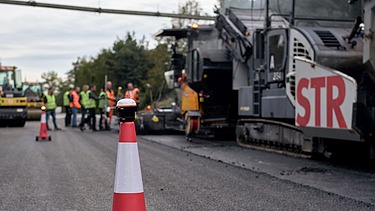 Foto von einer selbstfahrenden Absperr-Pylone mit einem Absperrhut darauf