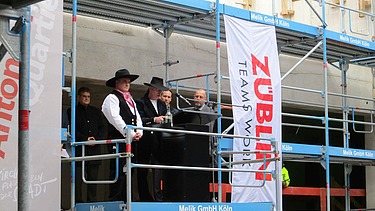 Richtfestkranz wird auf der Baustelle Antoniter Quartier in Köln gehisst. 