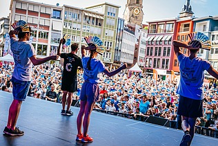 Foto von einer Bühne, wo vier Personen tanzen. 