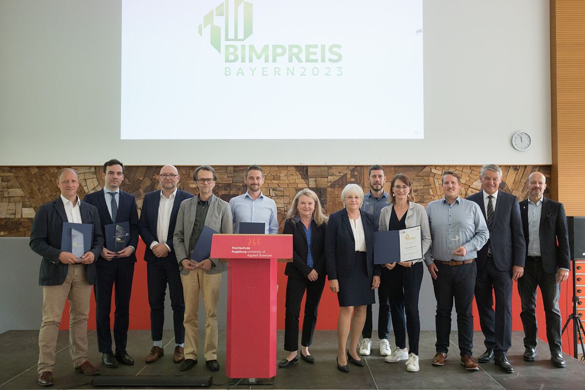 Foto von Preisträger:innen und Laudator:innen der BIM Preise Bayern 2023, im Hintergrund eine Bildschirmpräsentation