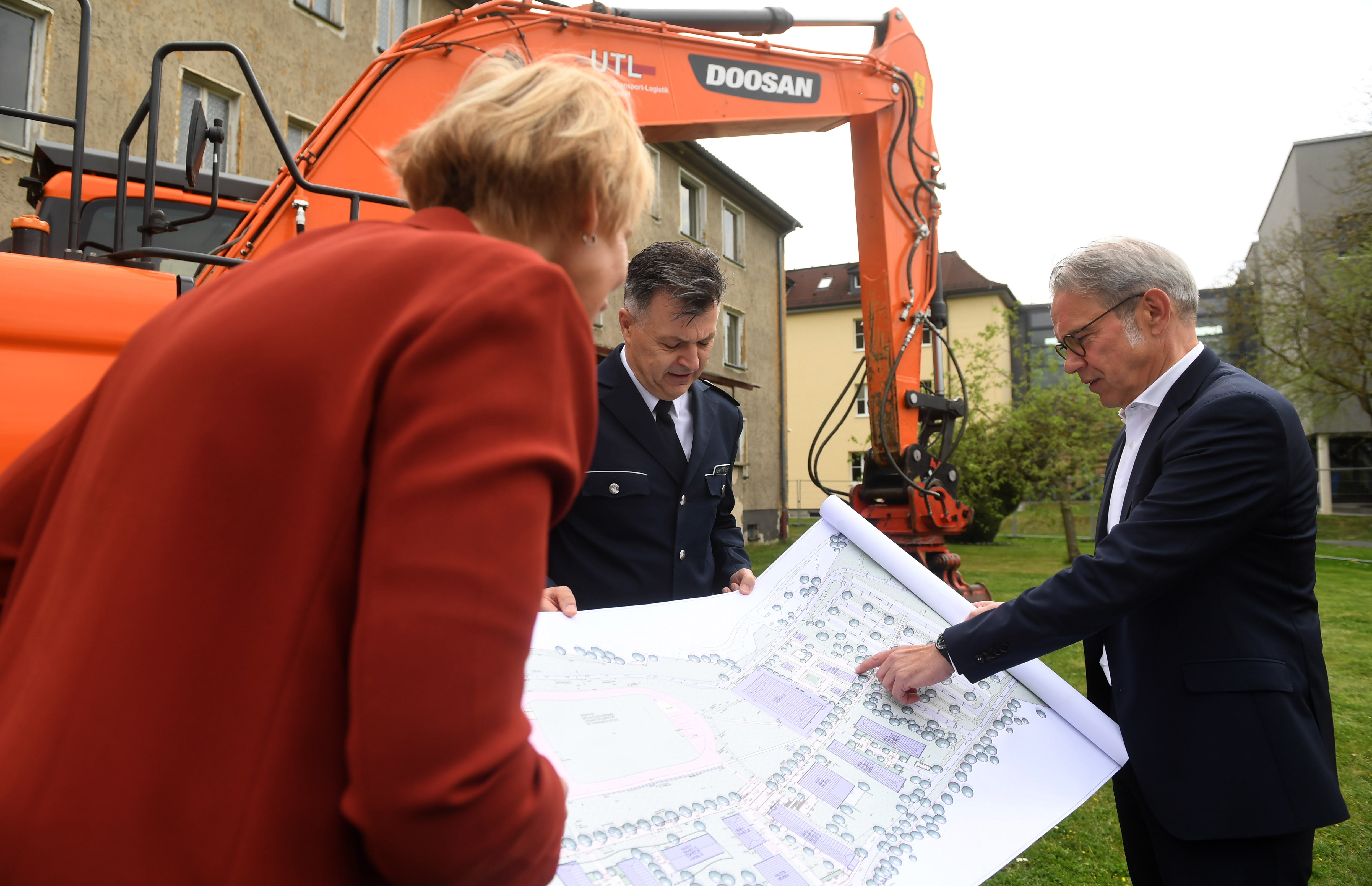 Foto drei Personen die sich Zeichnung anschauen. 