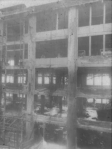  Schwarz-weiß Aufnahme von einem zerstörten mehrstöckigen Haus.