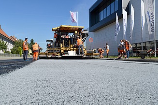 Foto von einer Asphaltiermaschine bei der Arbeit