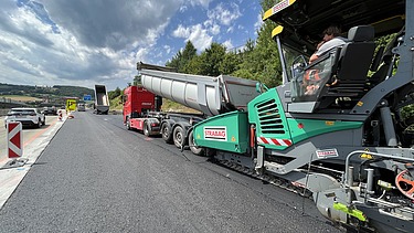 Foto von einer Asphaltbaumaschine bei der Arbeit