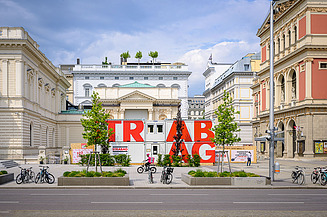 Foto von mehreren STRABAG Containern, die zwischen zwei historischen Gebäuden stehen