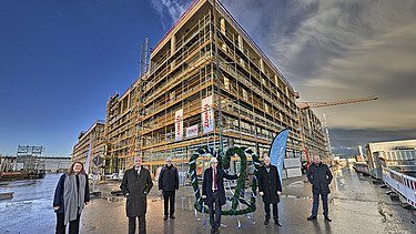 Foto von mehreren Personen die vorm Richtkranz stehen über dem LabCampus am Flughafen München.