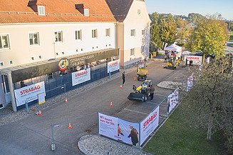Foto von eines Gebäudes mit einem Parkplatz umgeben von Bauzäunen