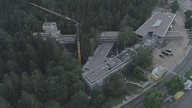 Foto in der Vogelperspektive von einem Wald in dem sich eine Baustelle befindet. 