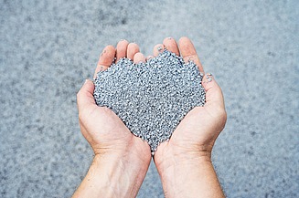 The picture shows two hands holding a pile of grey-blue balls