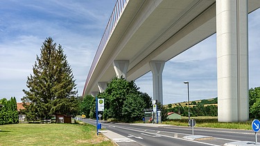Photo of a new valley bridge seen from below, next to a country road