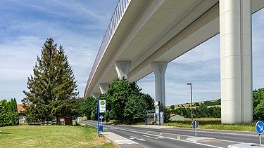 Photo of a new valley bridge seen from below, next to a country road
