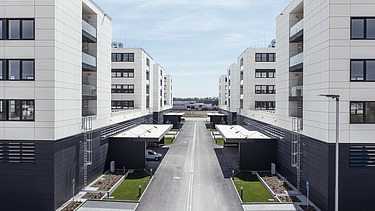 Visualisierung vom IN-Campus mit vier symmetrisch angeordnete Gebäudemodule in U-Form, mit Blick zwischen den Gebäuden. 