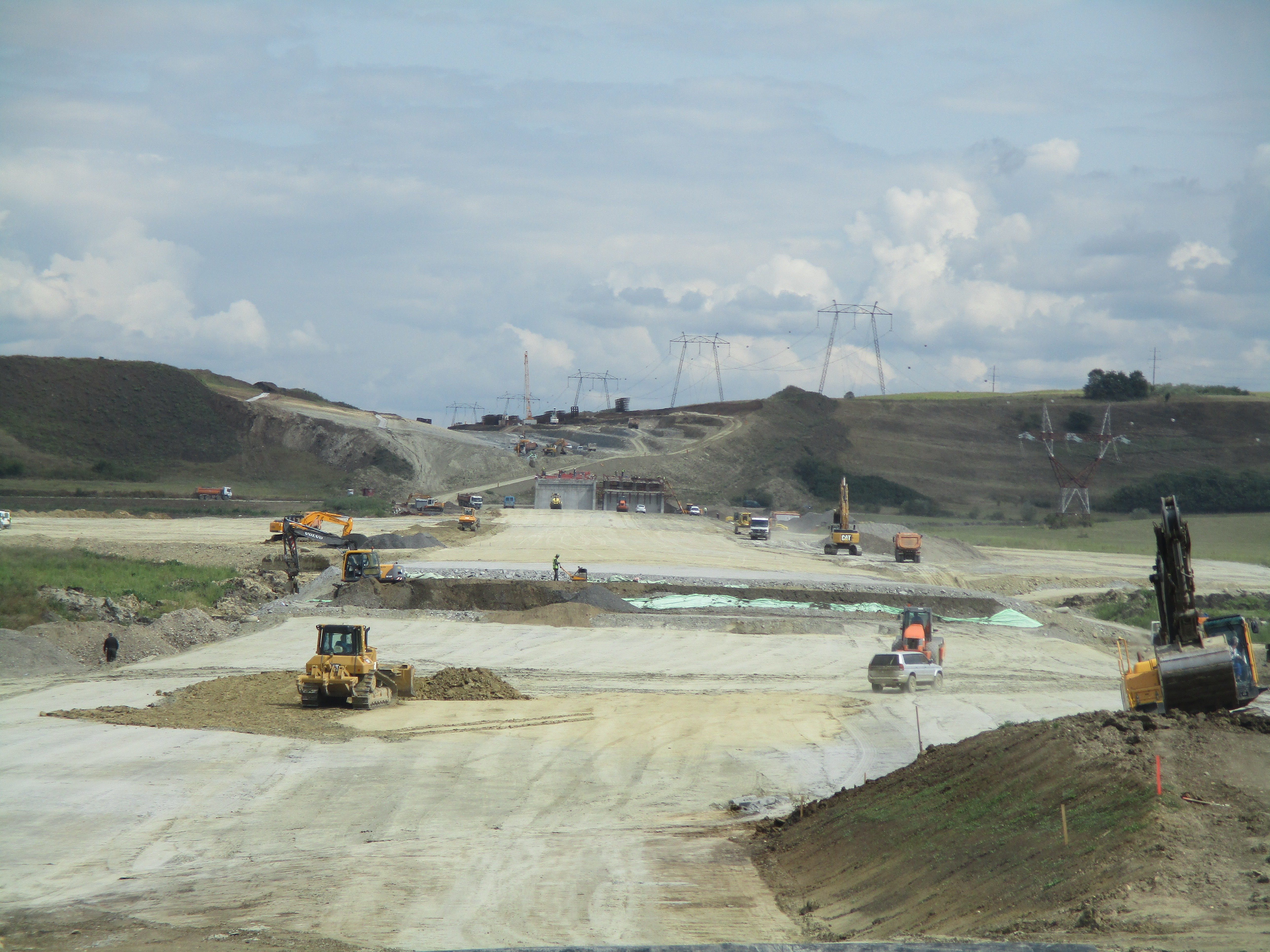 Photo shows a highway construction site with several machines at work