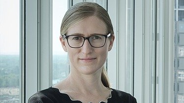 Foto von Marianne Jakl, die vor einem Fenster steht
