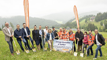 Foto von mehreren Personen beim Spatenstich des PV-Parks Ratten, diese stehen auf einer grünen Wiese