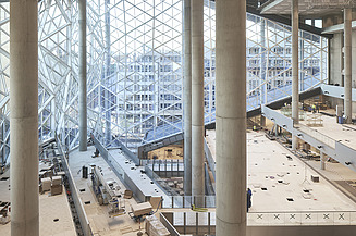 Foto von einer Baustelle. Es ist ein großer Raum zusehen, wo der Boden verlegt wird.