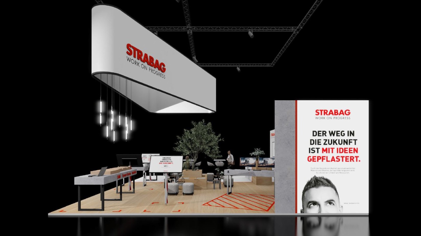 Foto eines modernen Messestands mit Roll-up rechts, Bestuhlung und Tischen, der Hintergrund ist schwarz