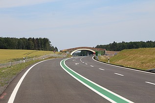 Foto einer leeren Fahrbahn, die in einer Unterflurtrasse mündet