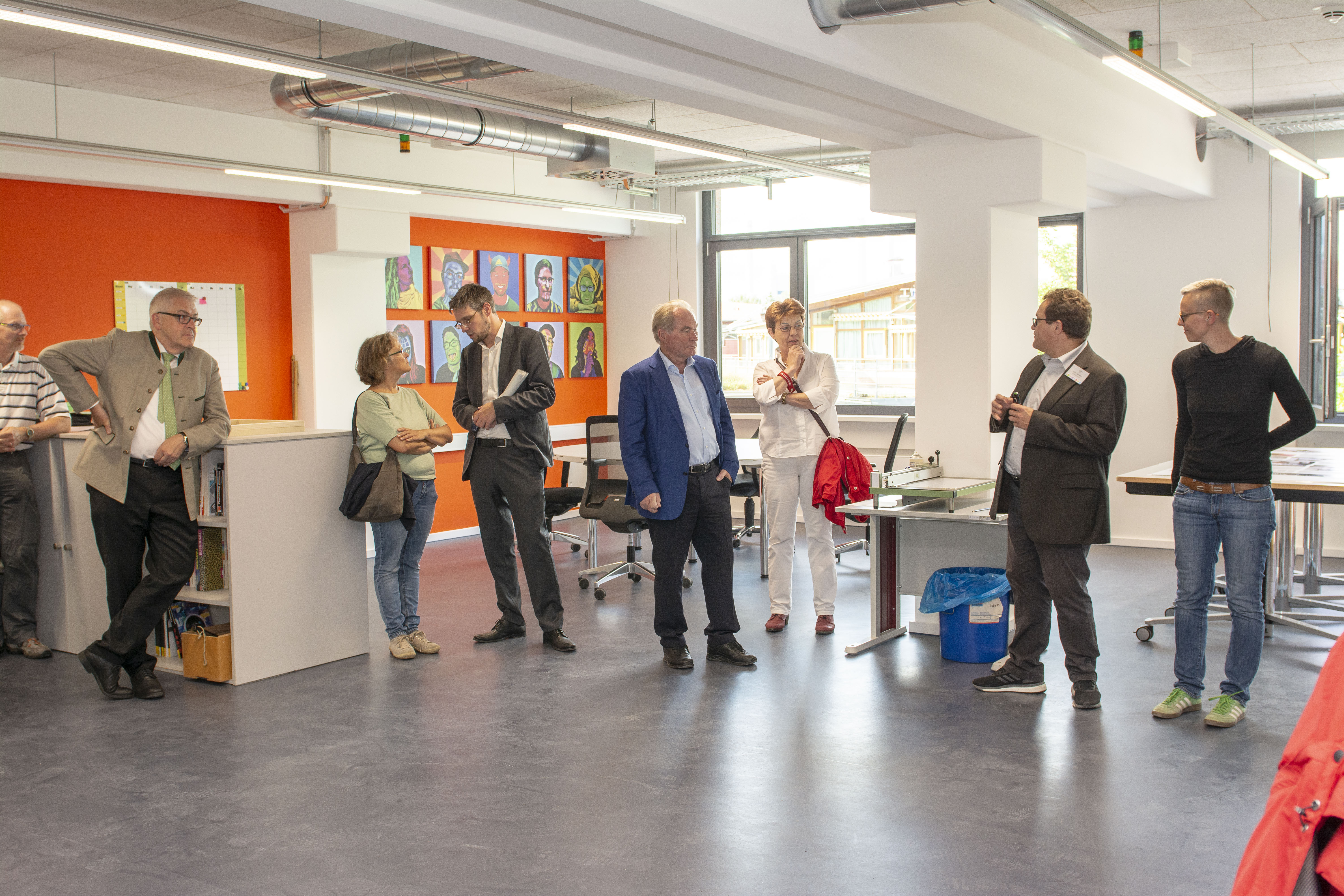 Foto von einem sich unterhaltenden Personen in einem Semianraum. 