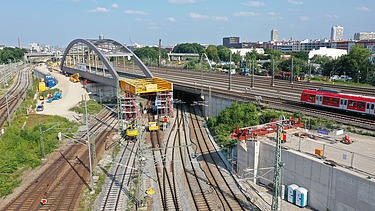 Foto vom Bau einer Brücke über Schienen aus der Vogelperspektive. 