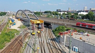 Foto vom Bau einer Brücke über Schienen aus der Vogelperspektive. 