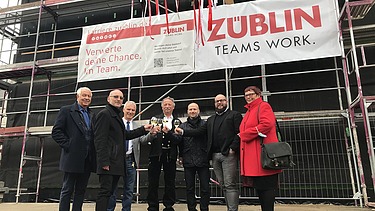 Foto von mehren Personen beim Anstoßen nach dem Richtstoß. 