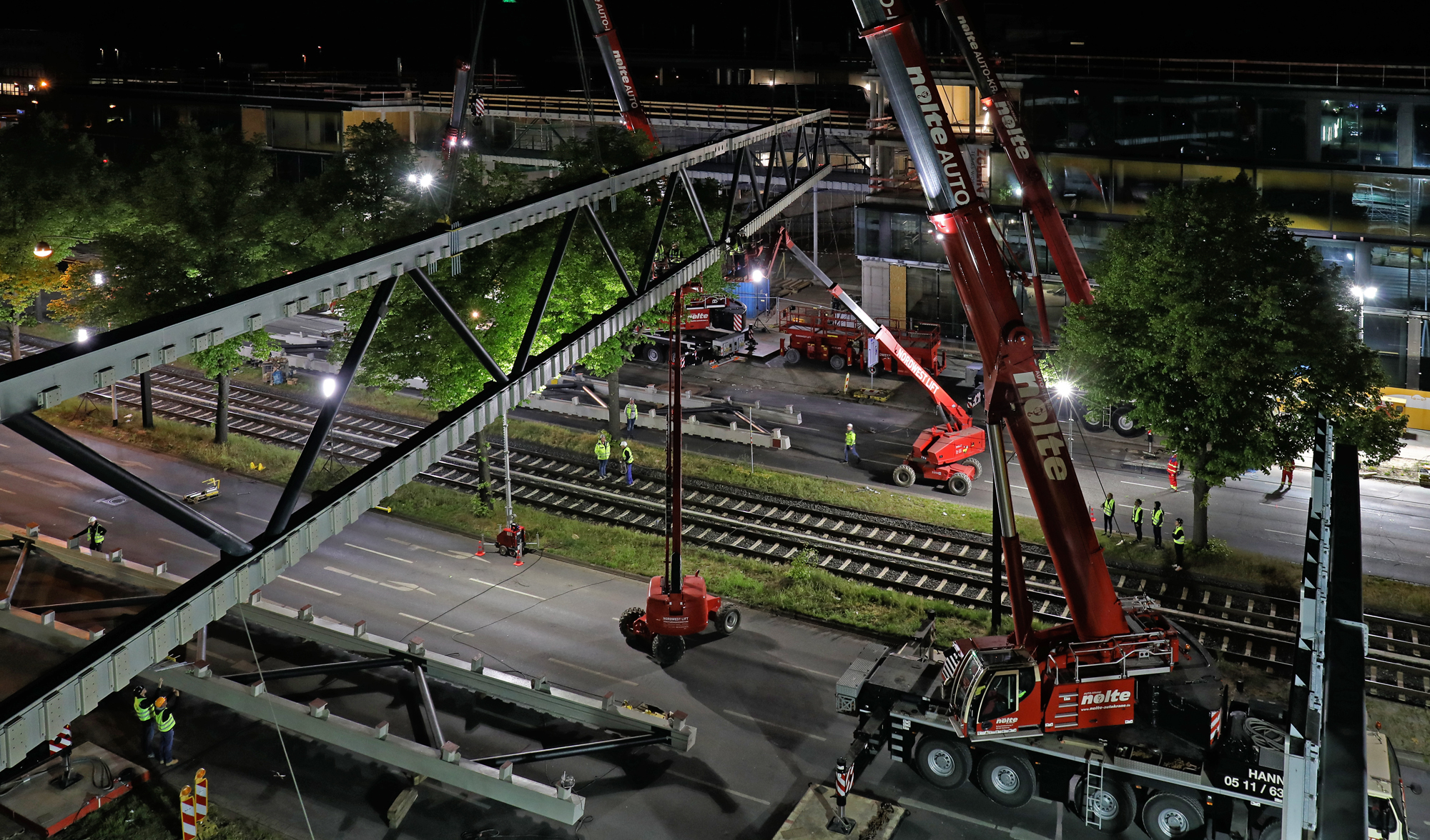 Foto von einer Brücke die grade gebaut wird aus der Vogelperspektive bei Nacht. 