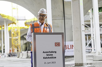 Foto von einer Person in Schutzausrüstung die eine Rede hält.    