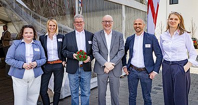 Elegant gekleidete Menschen stehen vor einem Zelt