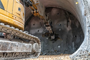 Nahaufnahme von einem Bagger der einen Tunnel gräbt.  